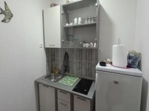 una pequeña cocina con fregadero y encimera en Rooms Providenca, en Gradac
