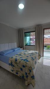 1 dormitorio con 1 cama con manta azul y amarilla en Loft Belas Praias, en Arraial do Cabo