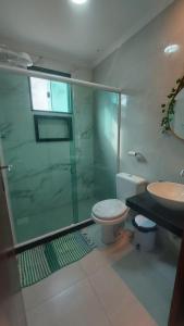 y baño con ducha, aseo y lavamanos. en Loft Belas Praias, en Arraial do Cabo