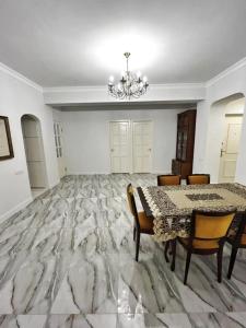 a dining room with a table and chairs and a chandelier at Апартаменты с тремя спальнями in Yerevan