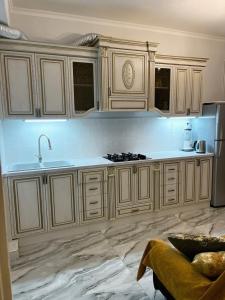 a kitchen with white cabinets and a sink at Апартаменты с тремя спальнями in Yerevan