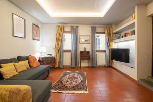 ein Wohnzimmer mit einem Sofa und einem Flachbild-TV in der Unterkunft Borgo La Croce Apartment in Florenz