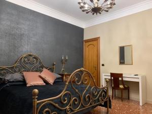 um quarto com uma cama, uma secretária e um lustre em Anna Rooms em Aprilia