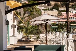 a row of tables and umbrellas on a patio at Miramare Sea Resort & Spa in Ischia