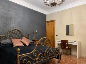 um quarto com uma cama, uma secretária e um lustre em Anna Rooms em Aprilia