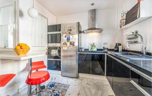 een keuken met een roestvrijstalen koelkast en een rode kruk bij Amazing Home In Aznalczar With Wifi in Aznalcázar