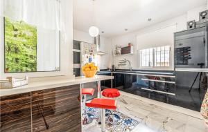 una cucina con bancone e sgabelli rossi di Amazing Home In Aznalczar With Wifi ad Aznalcázar