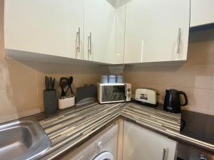a kitchen with a sink and a microwave on the counter at Cosy studio apartment - recently renovated! in Mansfield