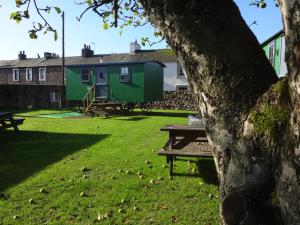 einen Park mit einem Picknicktisch und einem grünen Haus in der Unterkunft Sian's Retreat in Bowness-on-Solway