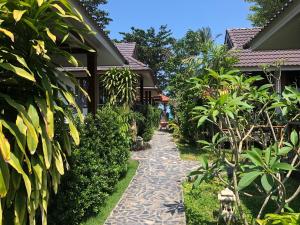 Pen's Bungalow Koh Phangan في ثونغ نايبان ياي: ممشى من خلال حديقة منزل