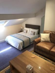 pokój hotelowy z łóżkiem i kanapą w obiekcie The Bowden Lodge w mieście Southport