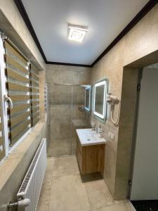 ein Bad mit einem Waschbecken und einer Dusche in der Unterkunft Шале Парламент, Яблуниця in Jablunyzja