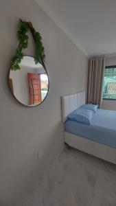 a bedroom with a mirror and a bed and a window at Loft Belas Praias in Arraial do Cabo
