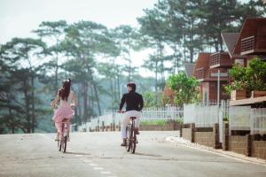 un hombre y una mujer montando bicicletas por una calle en The Tropicana B'la Village, en Berla (2)
