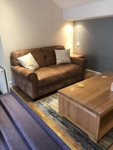 a living room with a brown couch and a coffee table at The Bowden Lodge in Southport