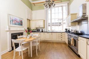 a kitchen with a table and chairs and a stove at 21 Montpellier House - By Luxury Apartments in Cheltenham