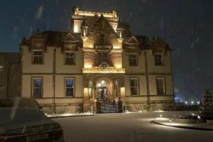 a large building with lights on it at night at Fabulous Lodges at Cameron House, Loch Lomond in Balloch