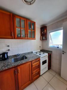 cocina con fregadero y fogones horno superior en Apartamento Valencia en Mar del Plata