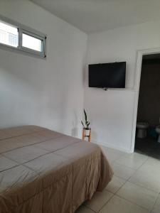 1 dormitorio con 1 cama y TV de pantalla plana en la pared en Apartamento Valencia en Mar del Plata