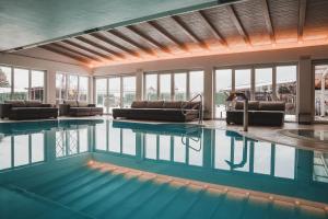 una piscina con divani e sedie in un edificio di Residence Montani a Laces