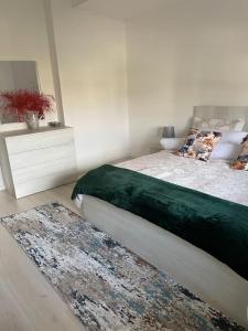 ein Schlafzimmer mit einem Bett und einem Teppich auf dem Boden in der Unterkunft Spacious apartment in luxury residence in Çeliku