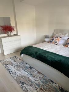 a bedroom with a bed and a rug on the floor at Spacious apartment in luxury residence in Çeliku