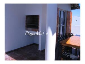 a dining room with a table and a window at Playa MaLú in Las Toninas