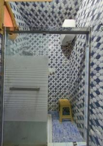 a shower with a yellow stool in a bathroom at شقق فندقية طانطان in Tan-Tan