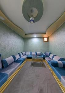 uma sala de espera com um sofá azul e uma mesa em شقق فندقية طانطان em Tan-Tan