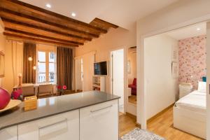 a kitchen and living room with white cabinets and a bed at Blasco de Garay Apartment - Poble Sec in Barcelona