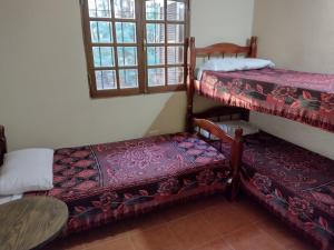 a room with two bunk beds and a table at La Rosada in Potrero de Garay +15 photos