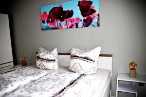um quarto com duas camas com almofadas e um quadro na parede em FeWo Sonja em Sankt Andreasberg