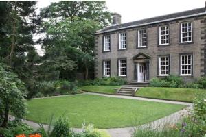 an old brick house with a lawn in front of it at Artist Hideaway Main Street Haworth in Haworth