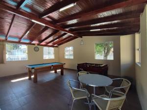 a room with a ping pong table and chairs at BRUNO KLEMTZ DK4 CASA PISCINA CHURRASQUEIRA SINUCA 3 AR WIFI 3 VaGAS 3 DORM in Itapema