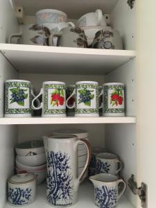 a shelf filled with blue and white cups and dishes at Les Tilleuls in Morbier