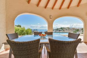 una mesa y sillas en un patio con vistas al océano en Villas Guzman - Loxi, en Benitachell