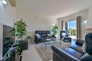 sala de estar con sofás y TV en Villas Guzman - Loxi, en Benitachell