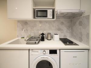 een keuken met een wasmachine en een magnetron bij Le Lion - Plain-pied, WIFI, YT Premium - 2RFHomes in Château-Thierry
