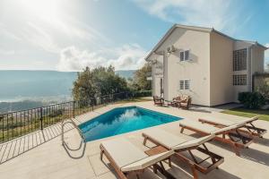 eine Villa mit einem Pool und Gartenmöbeln in der Unterkunft Villa Sladovic in Herceg-Novi