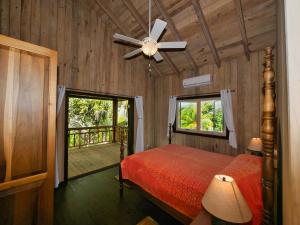 1 dormitorio con 1 cama y ventilador de techo en Hummingbird Beach House, en West Bay