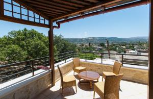 a balcony with chairs and a table and a view at Bezari pool villa in Metochia Fratzeskiana