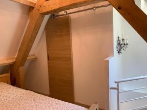 a bedroom with a wooden door in a attic at Gîte chez le Gaulois in Carsac-Aillac