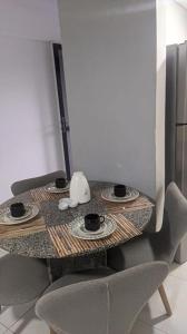una mesa pequeña con dos tazas y platos. en Flat Mobiliado na Ponta Verde, en Maceió