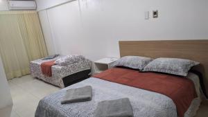 una habitación de hotel con 2 camas y una silla en Flat Mobiliado na Ponta Verde, en Maceió