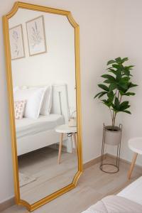 a large mirror in a living room with a couch at La Petite Fleur Guesthouse in Xylokastron