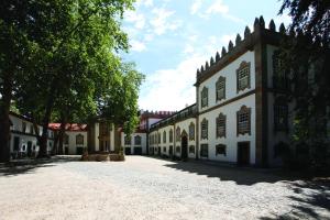 an empty courtyard of a building with trees in the background at Parador Casa Da Insua in Penalva do Castelo