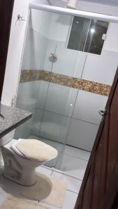 a bathroom with a glass shower with a toilet at Apartamento em Pipa in Pipa