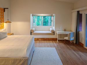 a bedroom with a bed and a window with a bench at Cloud Forest Lodge by Böëna in Monteverde Costa Rica