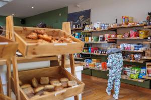 een persoon die in een winkel naar voedsel kijkt bij Chalets De Roos in Beerze