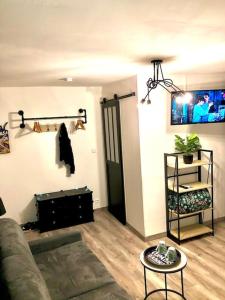 a living room with a couch and a table at Le Mécanique Room centre ville, parking gratuit in Sens